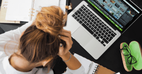 female business owner experiencing anxiety over a laptop and some papers