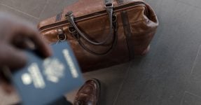 A man holding a passport next to a travel bag, Bulgarian startup visa