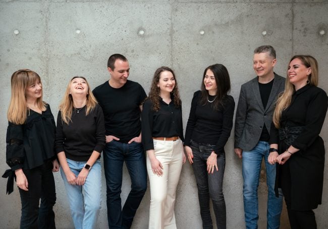 Picture with the team of Underline Ventures, 5 women and 2 men, next to a gray wall