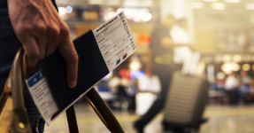 A guy holding a boarding pass in a passport