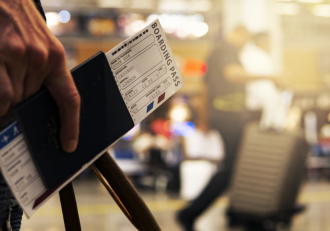 A guy holding a boarding pass in a passport