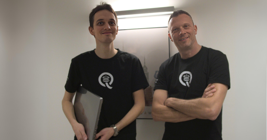 2 men, founders of Questa, next to a wall
