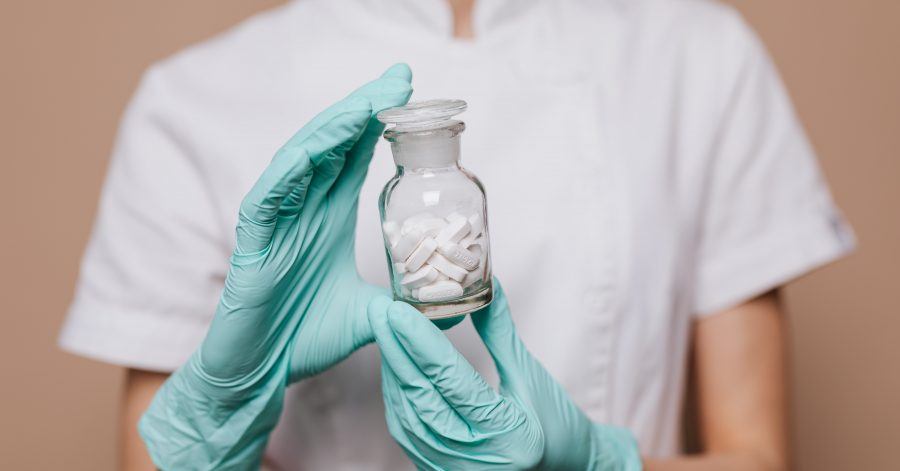 A woman holding a bottle of pills drug development