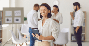 female founder with a white shirt holding papers, smiling, scaling startup