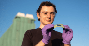 A portrait of a scientist holding a prototype of artificial leaves