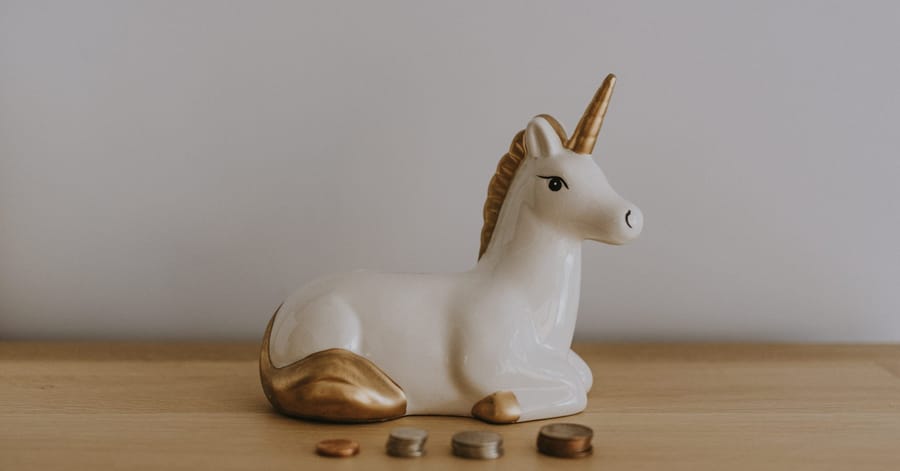 Unicorn money box and coins stacked
