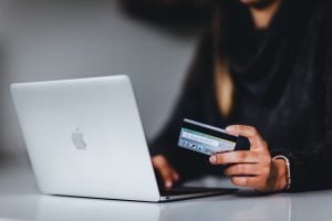 A woman shopping online holding a credit card